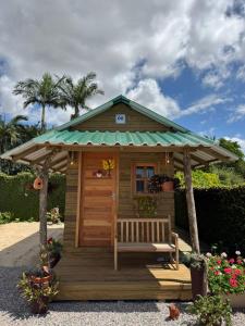 eine kleine Hütte mit einer Bank und einem Pavillon in der Unterkunft Chalé rústico no centro de Tijucas in Tijucas