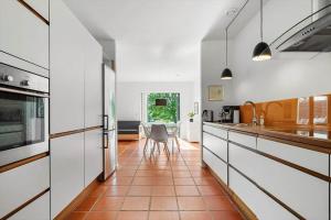 a kitchen with white cabinets and a red tile floor at 20424-Samso-Besser-Kirkevej-4-C in Langemark