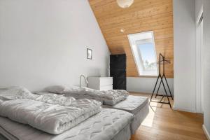two beds in a room with a wooden ceiling at 20424-Samso-Besser-Kirkevej-4-C in Langemark