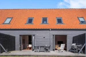 a building with chairs and tables on a patio at 20424-Samso-Besser-Kirkevej-4-C in Langemark
