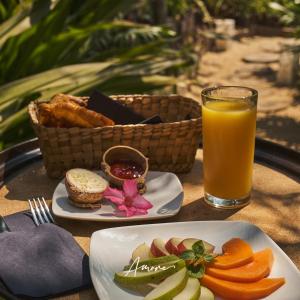 a table with two plates of food and a glass of orange juice at Casa A'more in Cuatunalco
