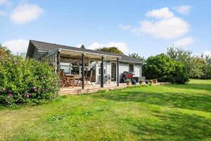 a small house with a wooden deck in a yard at 30732-Odder-Skovgardsparken-32 in Amstrup