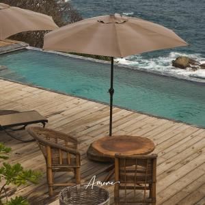 a table and chairs with an umbrella next to a pool at Casa A'more in Cuatunalco