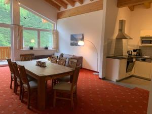 a kitchen and dining room with a wooden table and chairs at alpsrental Apartments Freja Obertauern in Obertauern