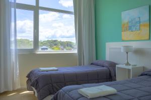 two beds in a room with a large window at Cariló Sul Mare in Carilo +58 photos