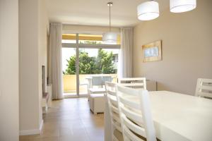 a dining room with a table and chairs and a window at Cariló Sul Mare in Carilo