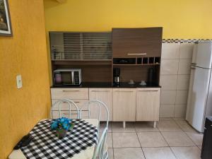 a small kitchen with a table and a refrigerator at Kitinet Verolme AFP 1 in Angra dos Reis