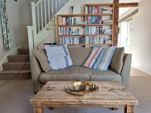 un salon avec un canapé et une table basse dans l'établissement Hogchester Cottage, à Bridport