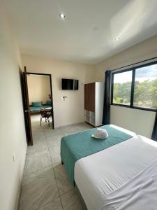 a bedroom with a bed and a large window at Hotel Puerto Tixkokob in Tixkokob