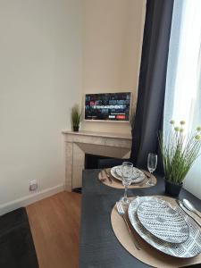 Un comedor con una mesa con platos y copas de vino. en Luberno studio lumineux parking inclus, en Cavaillon