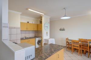 a kitchen and dining room with a table and a counter at 606 L'esclaier Cabanas - Seaside Paradise in Amanzimtoti