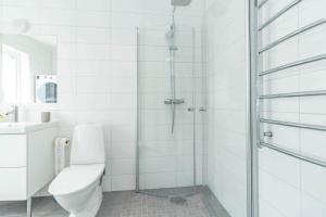 a white bathroom with a toilet and a glass shower at BLE833-Lyckeby-Knoesoevaegen-98 in Lyckeby
