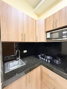 een keuken met een spoelbak en een magnetron bij Suite sector exclusivo in Machala