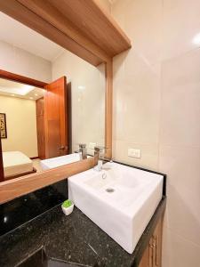 een badkamer met een witte wastafel en een spiegel bij Suite sector exclusivo in Machala