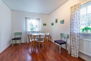 a dining room with a table and chairs at KRO802-Haeradsbaeck-Ellagoelshult-3 in Gäddegölshult +4 photos