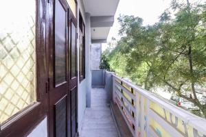eine offene Tür zu einem Balkon mit einem Baum in der Unterkunft Hotel O Grand Residency in Neu-Delhi