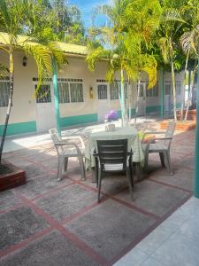 a table and chairs on a patio with palm trees at Hotel brisas del opía in Piedras