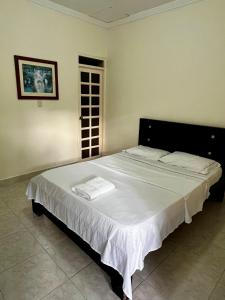a bedroom with a large bed with white sheets at Hotel brisas del opía in Piedras