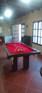 Una mesa de billar en una habitación con una cubierta roja. en Descanso Punta Mogotes, en Mar del Plata
