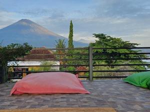 a red pillow sitting on a patio with a mountain at Amed Sari Beach Guesthouse in Amed