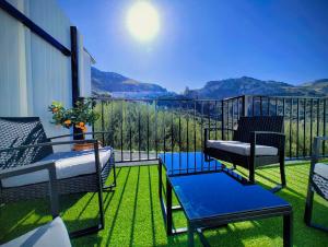 a balcony with chairs and a view of the mountains at Alojamiento La Nave de Zuheros in Zuheros