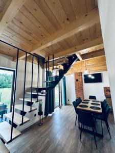 une pièce avec un escalier, une table et des chaises dans l'établissement Leśny Zakątek Brzezinki, 