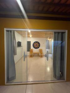 a glass door leading into a room with a table at Chalé vista mar in São Miguel do Gostoso +14 photos