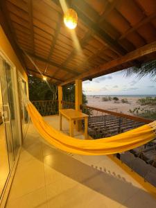 a hammock on the balcony of a house at Chalé vista mar in São Miguel do Gostoso