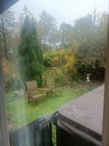 ダービーにあるWillow Lodgeの庭にベンチが2つある公園の風景