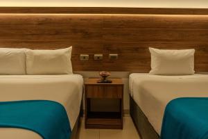 a hotel room with two beds and a side table at Antawa Classic in Moquegua