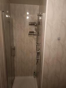 a shower with a glass door in a bathroom at Willow Lodge in Derby