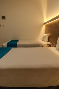 two beds in a hotel room with two beds at Antawa Classic in Moquegua +4 photos