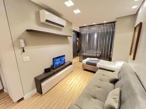 a living room with a couch and a flat screen tv at LK Santo Agostinho 7 in Belo Horizonte