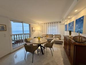 a living room with a table and chairs and a couch at Lisa Apartment in Menton
