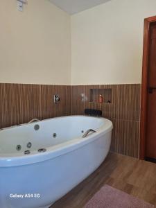 a large white bath tub in a bathroom at Chalé Aconchego in Camanducaia