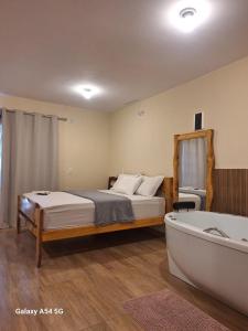 a bedroom with a bed and a bath tub at Chalé Aconchego in Camanducaia