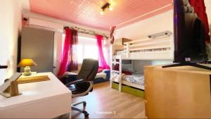 a room with a desk and a computer and a bedroom at Sams Rooms - Solo Female Guest House in Amadora