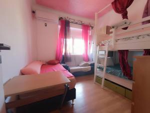 a bedroom with two bunk beds and a desk at Sams Rooms - Solo Female Guest House in Amadora