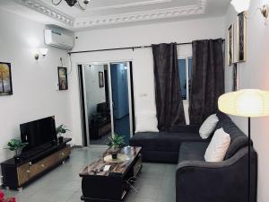 a living room with a couch and a tv at Appartement Brel in Yaoundé