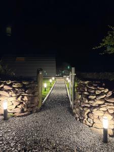 a stone wall with lights on it at night at LUXURY POD - Hidden Hills Waterville Farm in Waterville