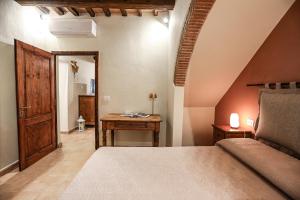 a bedroom with a bed and a wooden door at SweetHome San Martino in San Gimignano