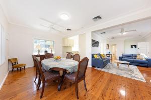 a dining room and living room with a table and chairs at Luxury 3 bedroom 2 bathroom full home with easy access near Cronulla in Lilli Pilli