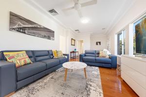 a living room with a blue couch and a table at Luxury 3 bedroom 2 bathroom full home with easy access near Cronulla in Lilli Pilli
