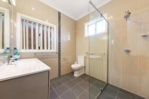 a bathroom with a toilet and a sink and a shower at Luxury 3 bedroom 2 bathroom full home with easy access near Cronulla in Lilli Pilli +10 photos