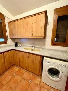 a kitchen with a sink and a washing machine at Hostal Todolella in Todolella +40 photos