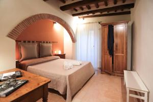 a bedroom with a large bed and a table at SweetHome San Martino in San Gimignano