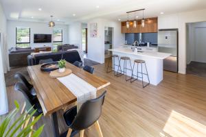 a kitchen and living room with a table and chairs at Halswell Quarry - Walk and Explore - 3 bed in Christchurch