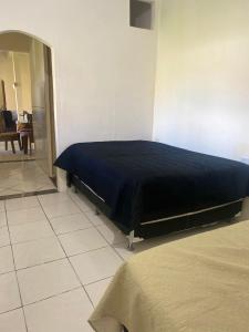 a bed in a room with a black blanket at Espaço de Iguaba Grande in Iguaba Grande +13 photos