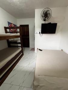 a room with a refrigerator and a fan on the wall at Toca do Pato Pousada in Trindade