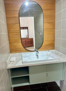 un baño con lavabo y espejo en Front Beach Villa, Pool & Basket, 